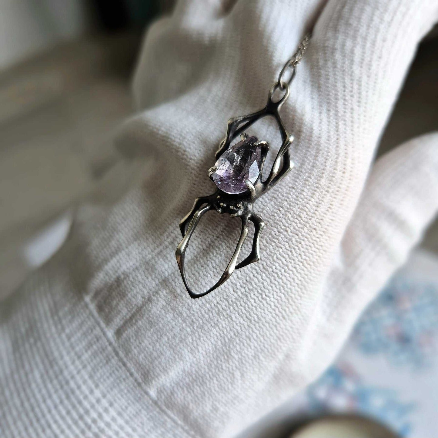 Handmade silver Spider pendant with Super Seven gemstone displayed upright, showing the pendant’s elegant structure