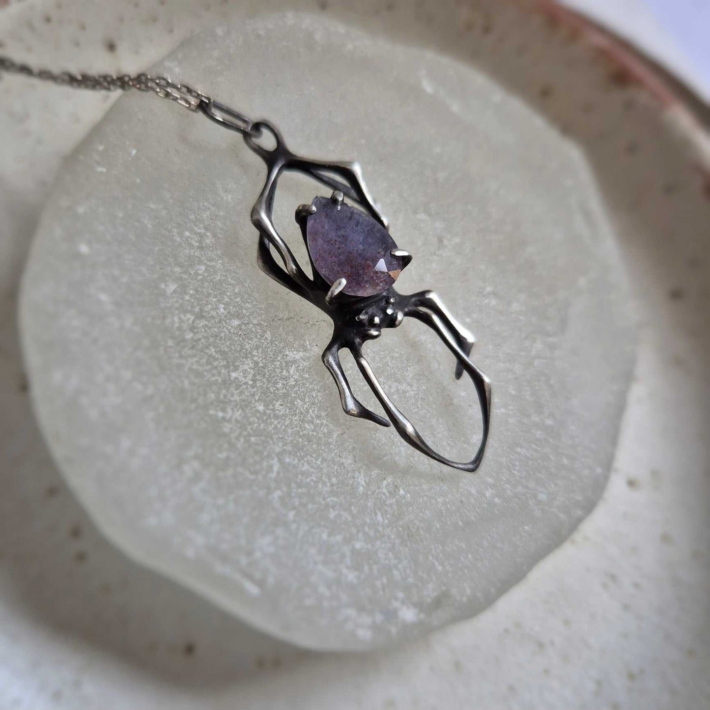 Close-up of iolite sunstone Spider pendant in oxidized sterling silver setting