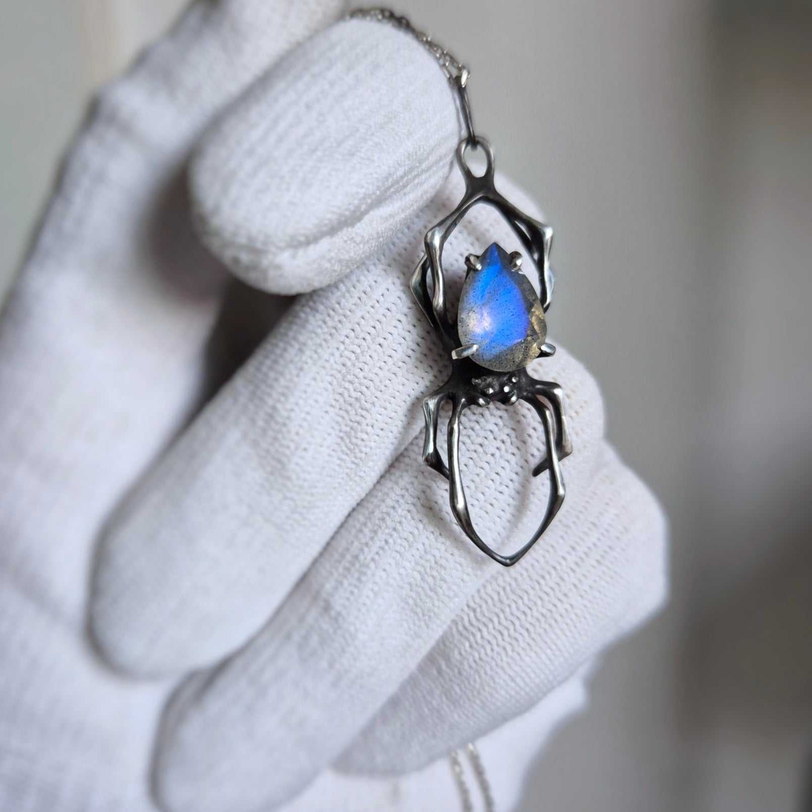 Meaningful spider pendant with labradorite, photographed in hands