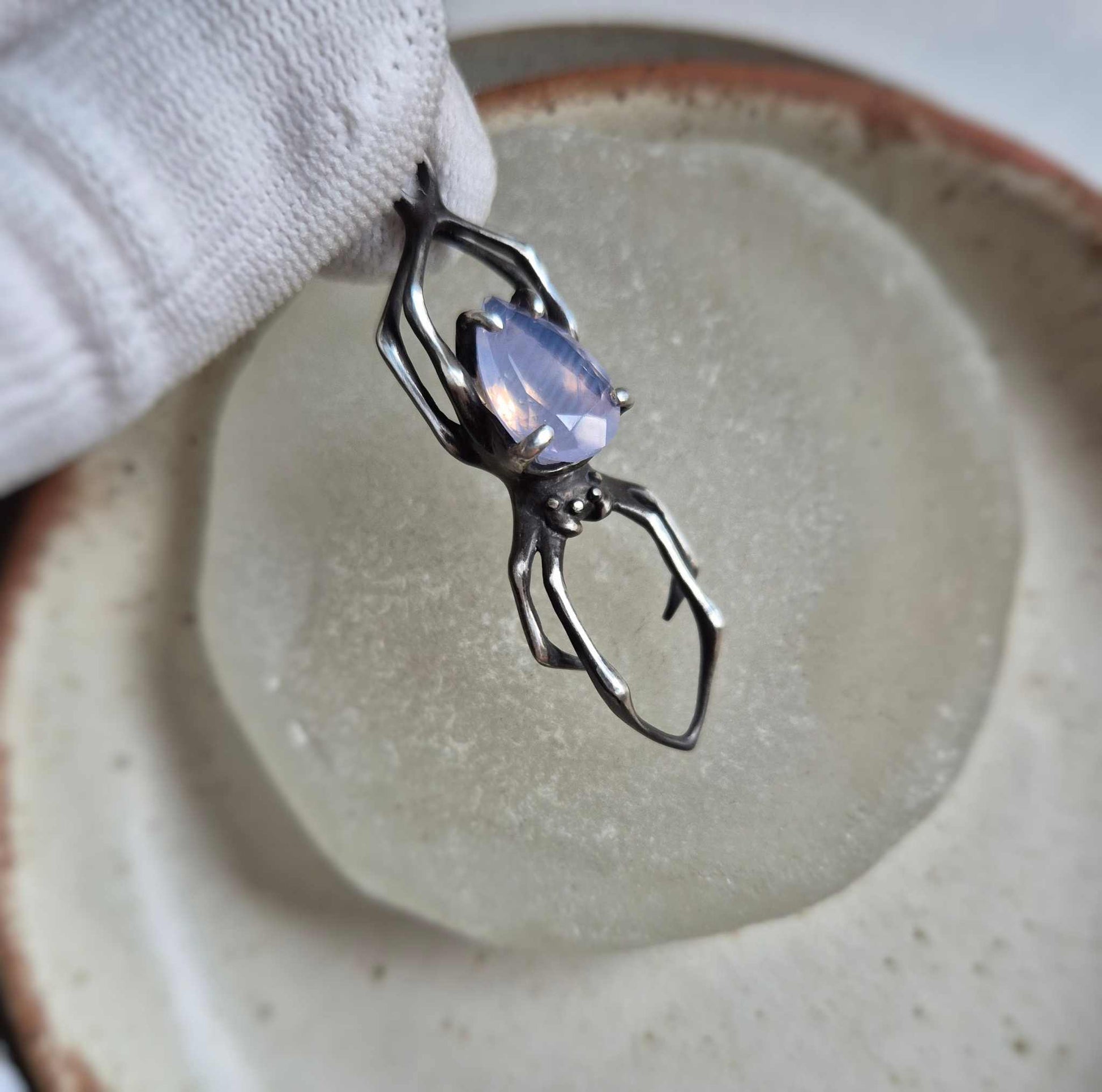 Silver spider pendant with faceted lavender quartz gemstone, displayed on neutral background