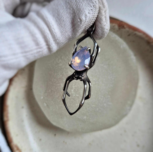 Silver spider necklace with lavender quartz gemstone on ceramic dish, handmade oxidized pendant