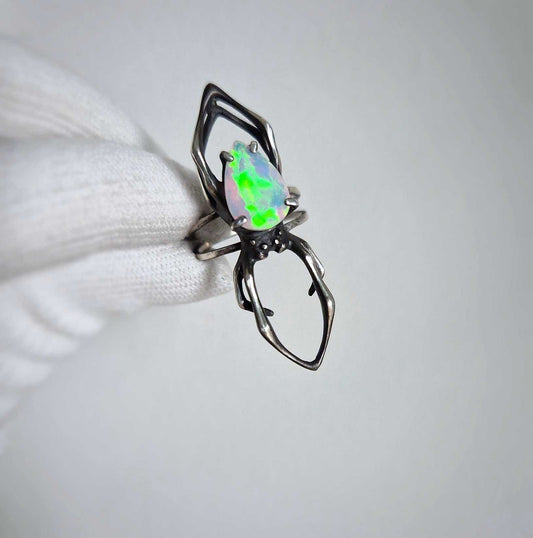 Detailed view of opal and silver spider ring in oxidized silver, handmade design