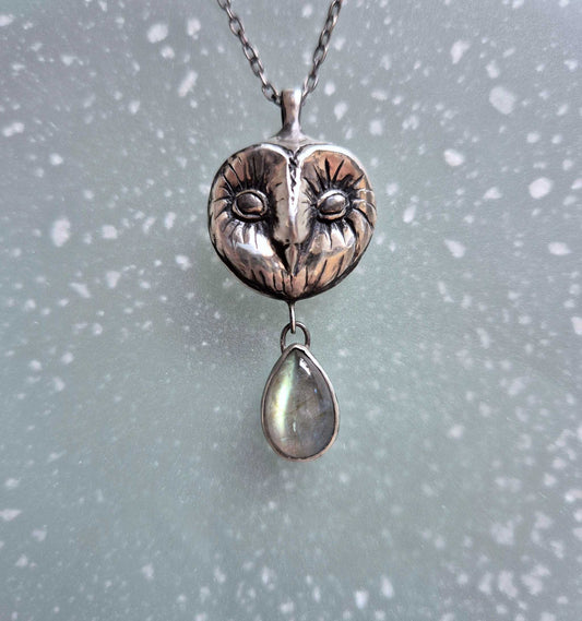 Front view of silver Owl necklace showing detailed Barn owl face and cyan labradorite flash.