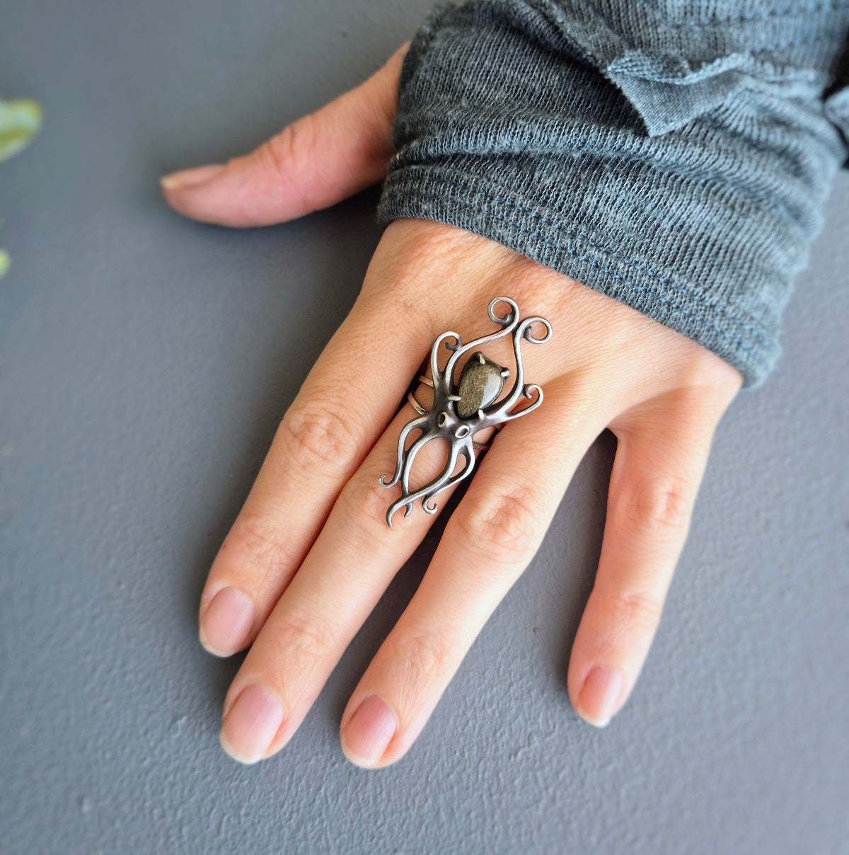 Elegant statement octopus-shaped silver ring on hand, with graceful curved tentacles