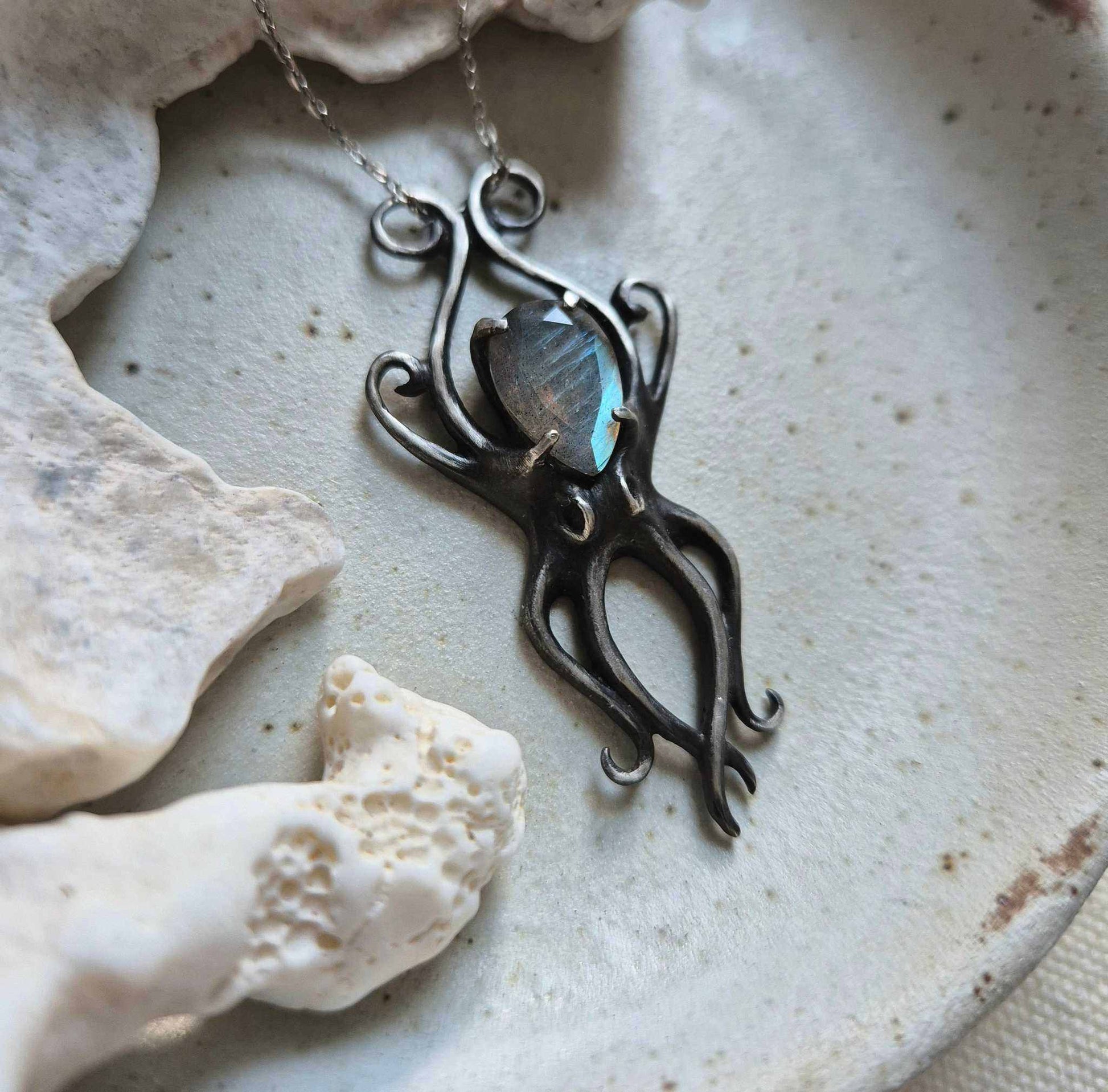 Close-up of Octopus necklace with faceted labradorite, set among natural textures