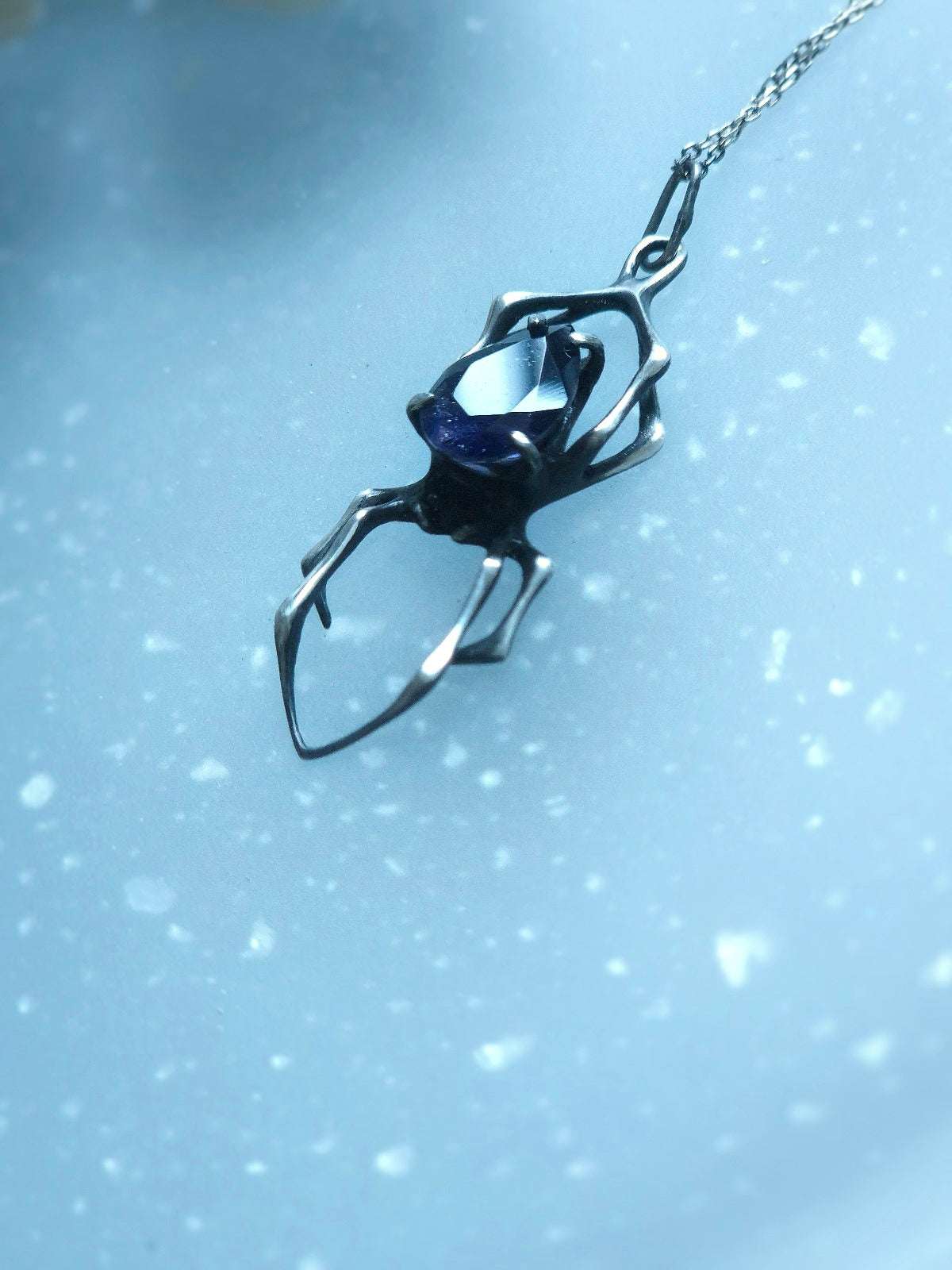 Shining silver spider pendant with speckled blue sunstone