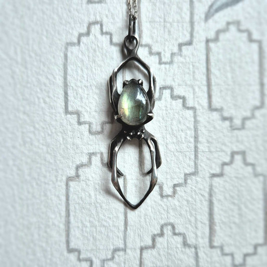Silver Spider necklace with labradorite gemstone photographed on geometric white background