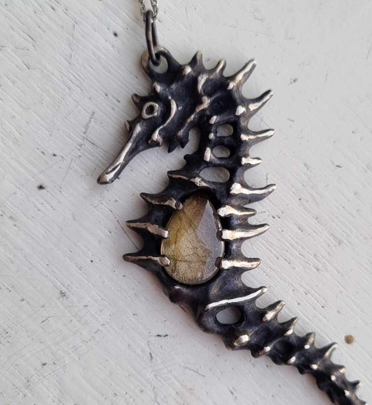 Close-up of a Silver Seahorse necklace featuring a striped labradorite, displayed on neutral background
