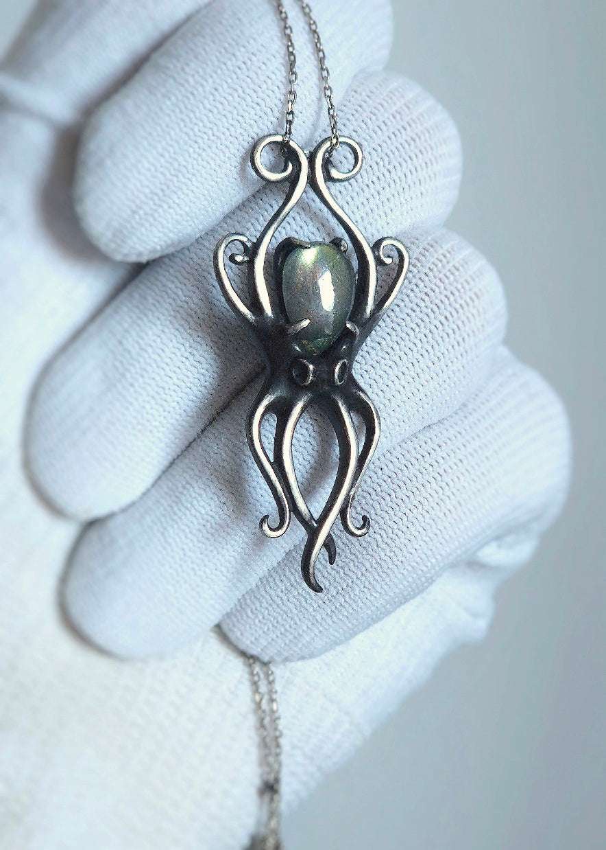 Close-up of silver octopus necklace with labradorite, highlighting curved tentacles and oxidized finish