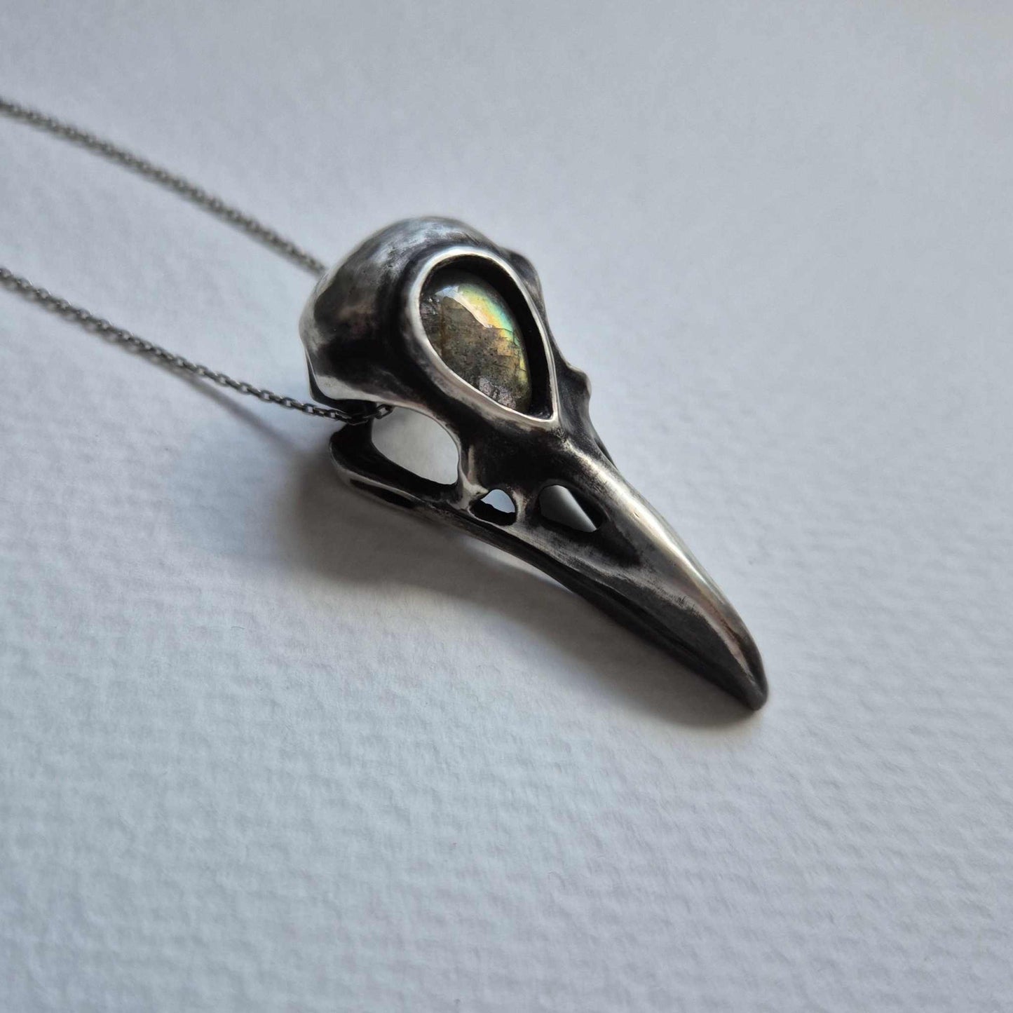 Sterling silver raven skull necklace with labradorite, side profile