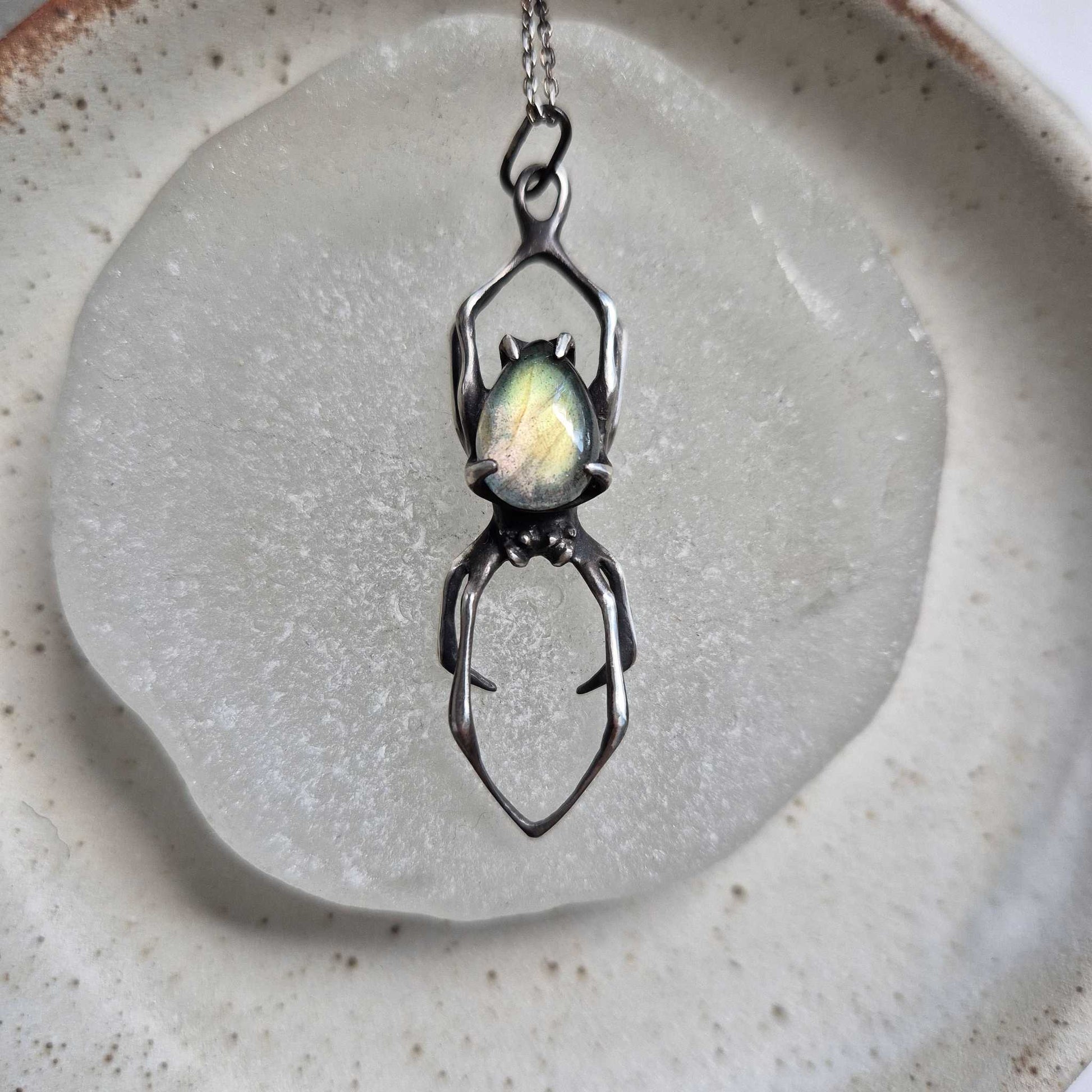 Silver Spider necklace with labradorite gemstone on a neutral background