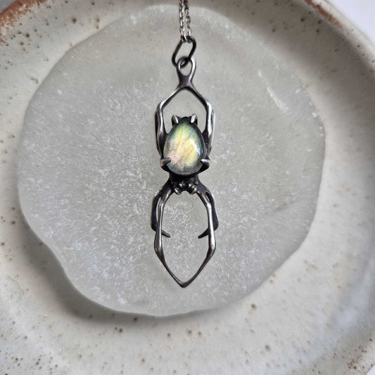 Silver Spider necklace with labradorite gemstone on a neutral background