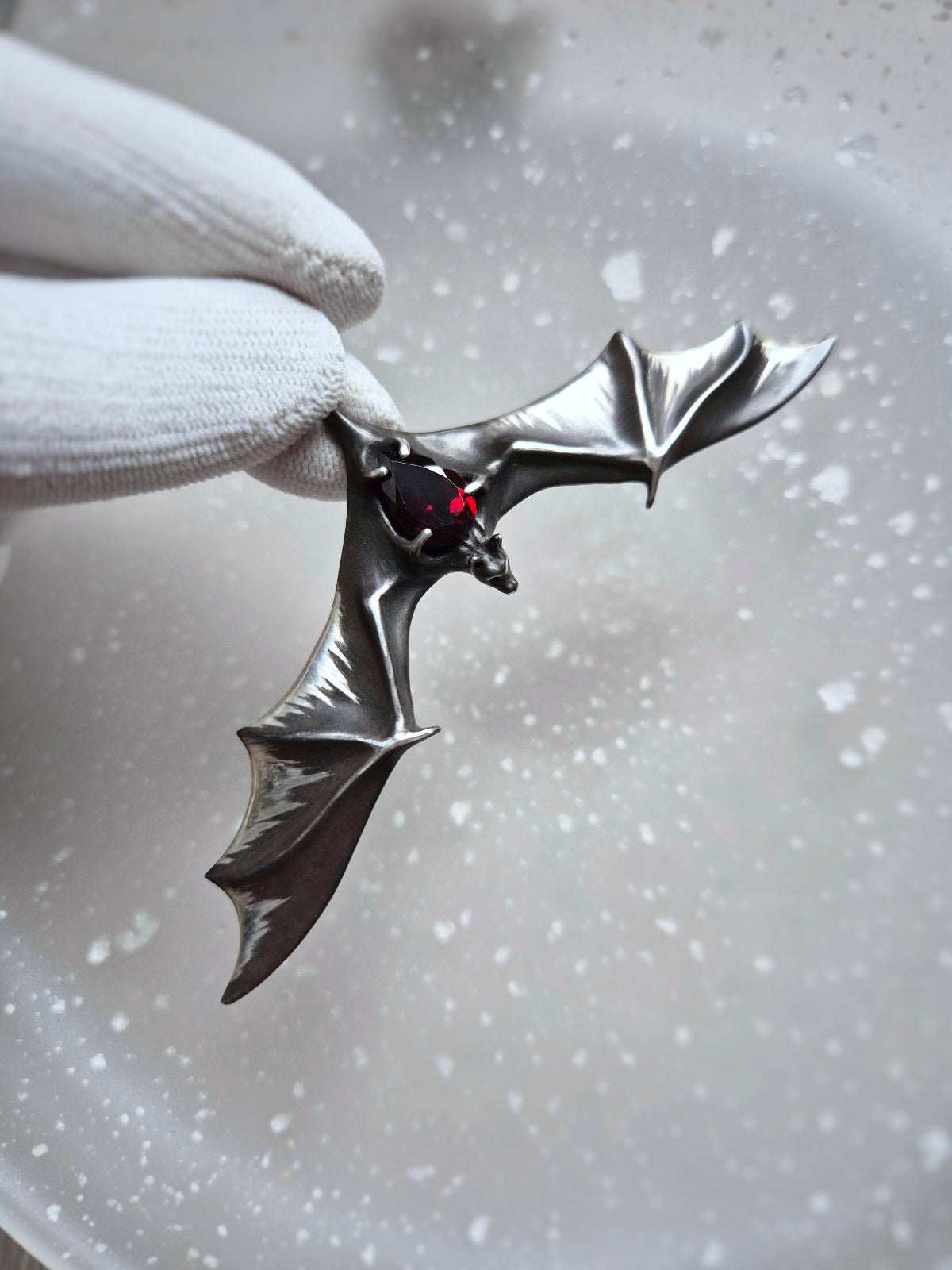 Silver Bat necklace with dramatic wing span and natural garnet gemstone