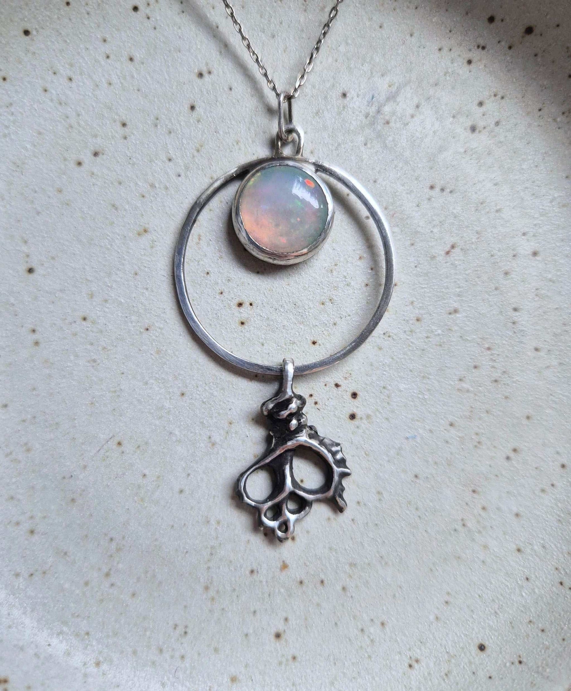 Handmade silver necklace with natural opal and sculptural shell charm — ocean talisman
