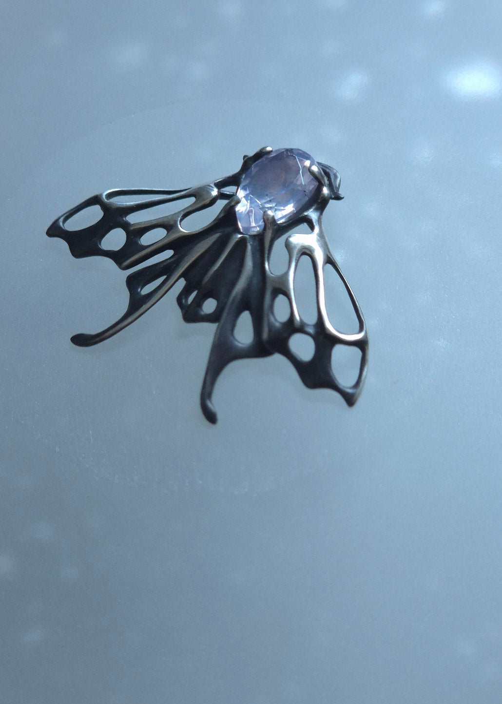 Oxidized silver Moth pendant with pale violet quartz gemstone in gentle lighting