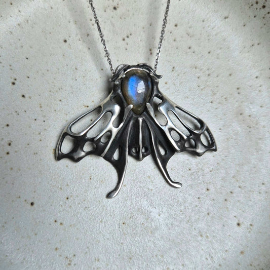 Handcrafted silver Moth necklace featuring a glowing blue labradorite
