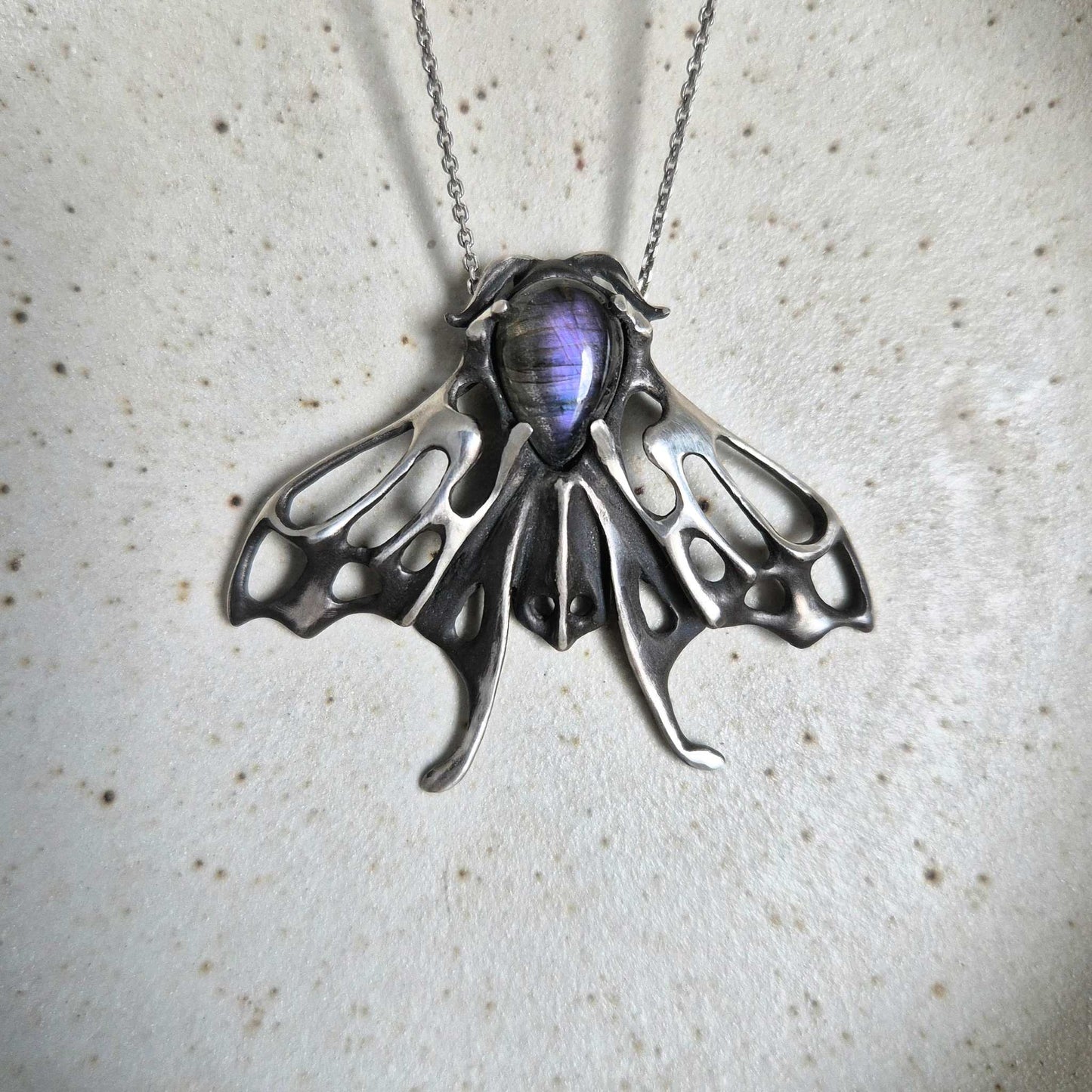 Handcrafted silver Moth necklace featuring a purple labradorite