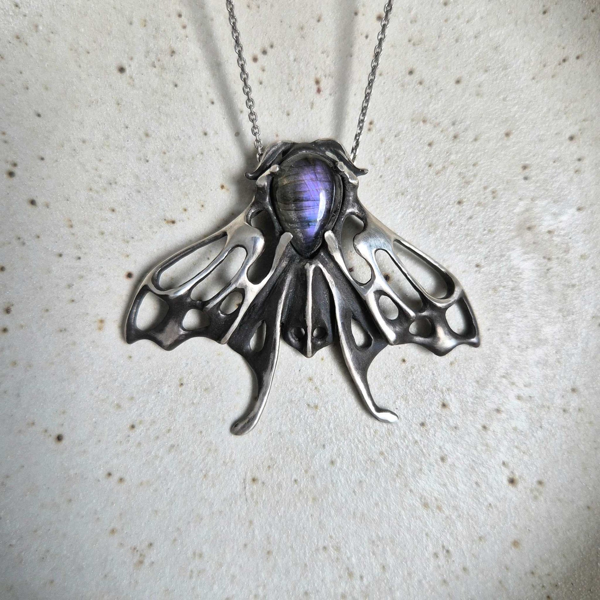 Handcrafted silver Moth necklace featuring a purple labradorite
