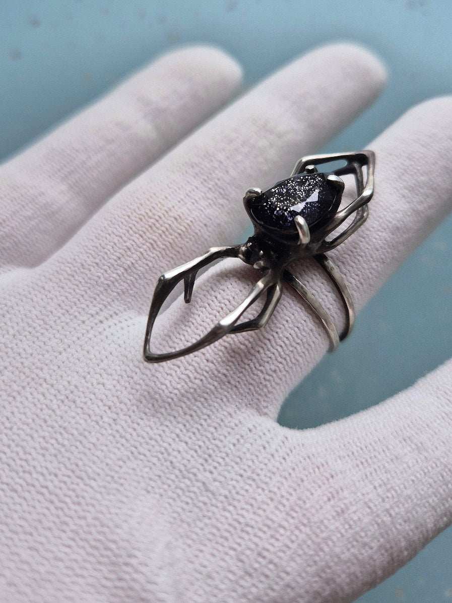 Statement spider ring with iolite sunstone on a white-gloved hand