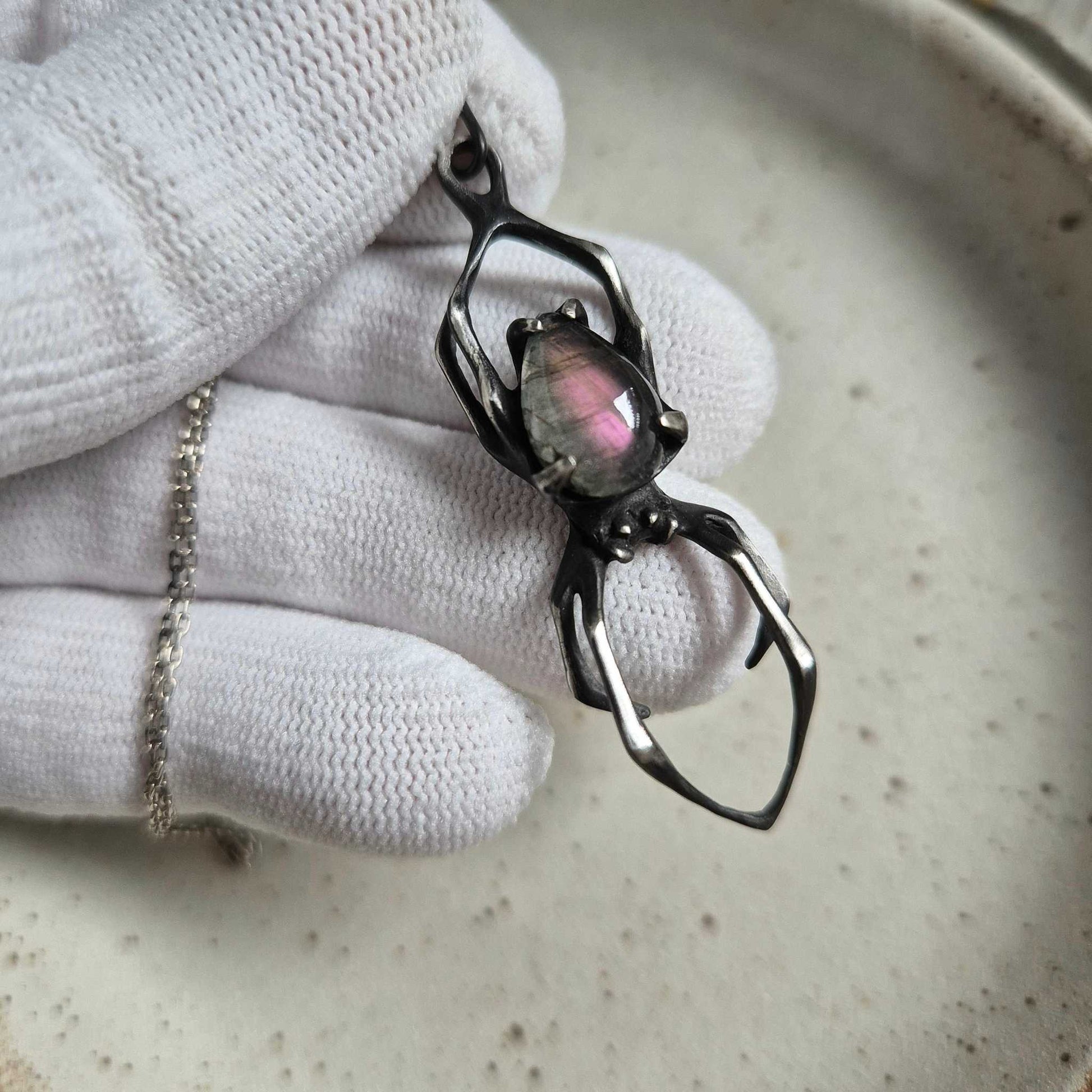 silver Spider necklace featuring purple labradorite cabochon, viewed from above