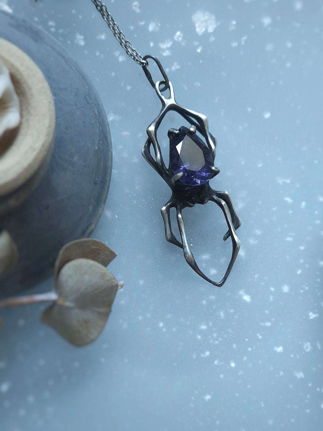 Symbolic spider necklace in soft light flatlay