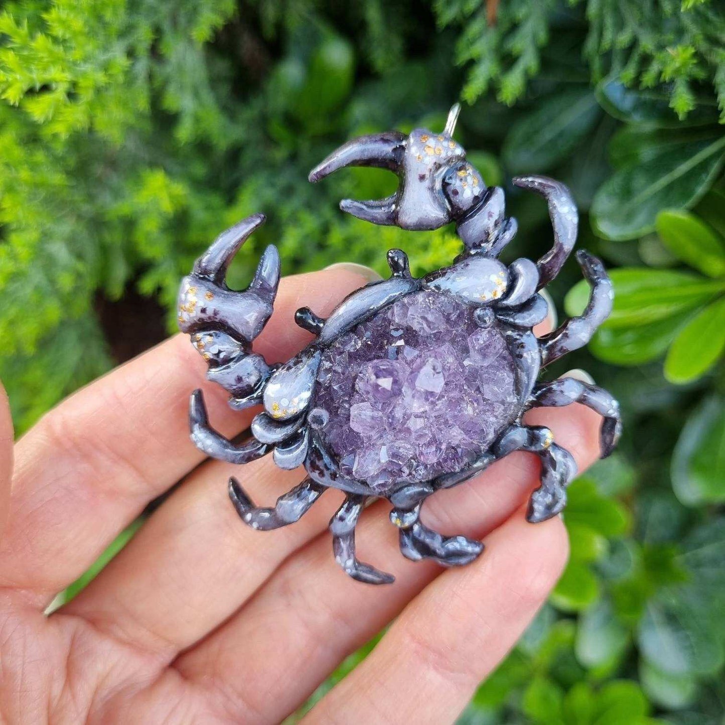 Sculpted Crab necklace featuring natural amethyst crystal, shown outdoors in bright light.