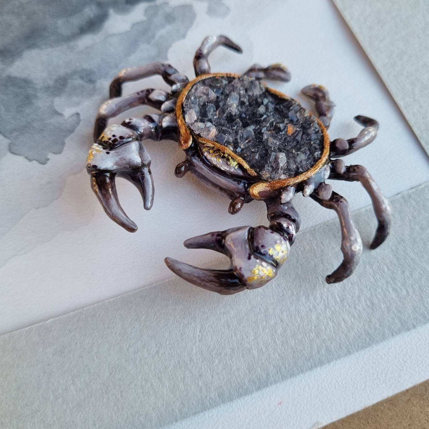 Top view of crab sculpture with smoky quartz and painted details.