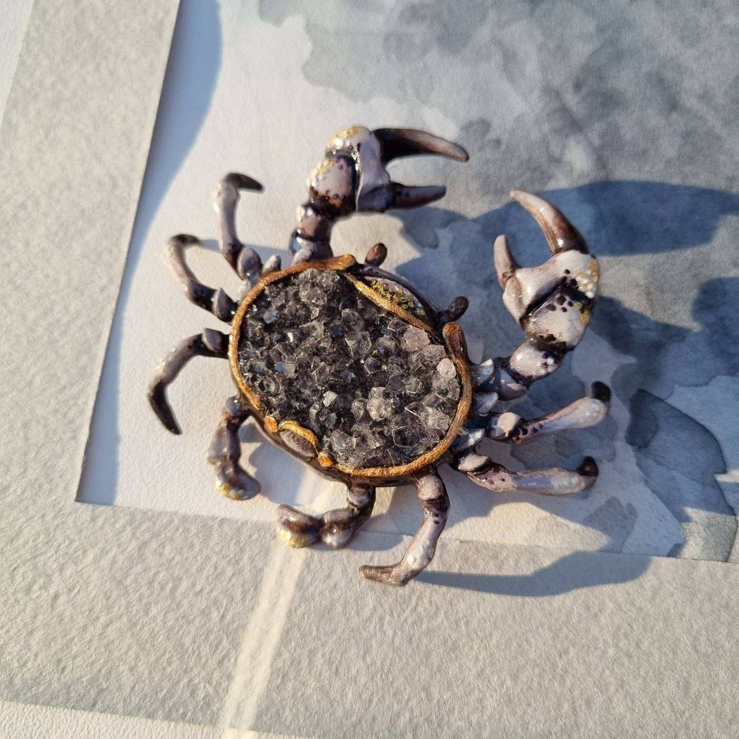 Close-up of collectible crab figurine with crystal center and detailed legs.
