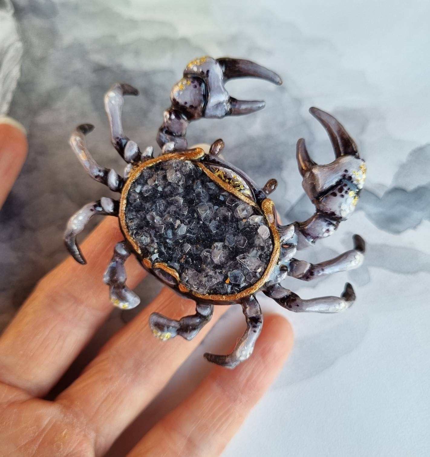 Close-up of collectible crab figurine with crystal center and detailed legs.