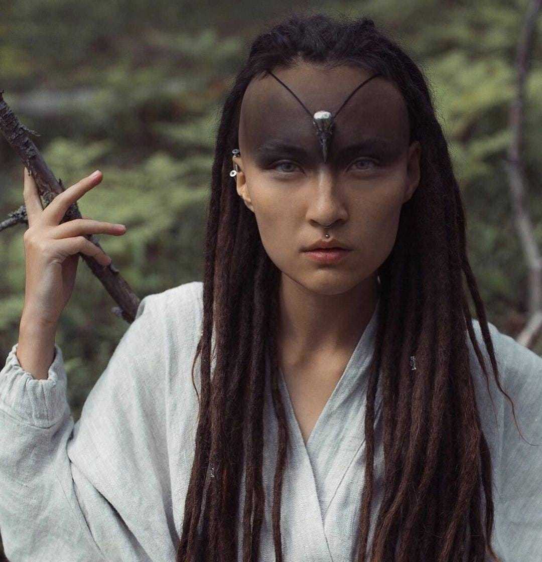 Model wearing silver raven skull necklace on her forehead as a symbolic centerpiece.