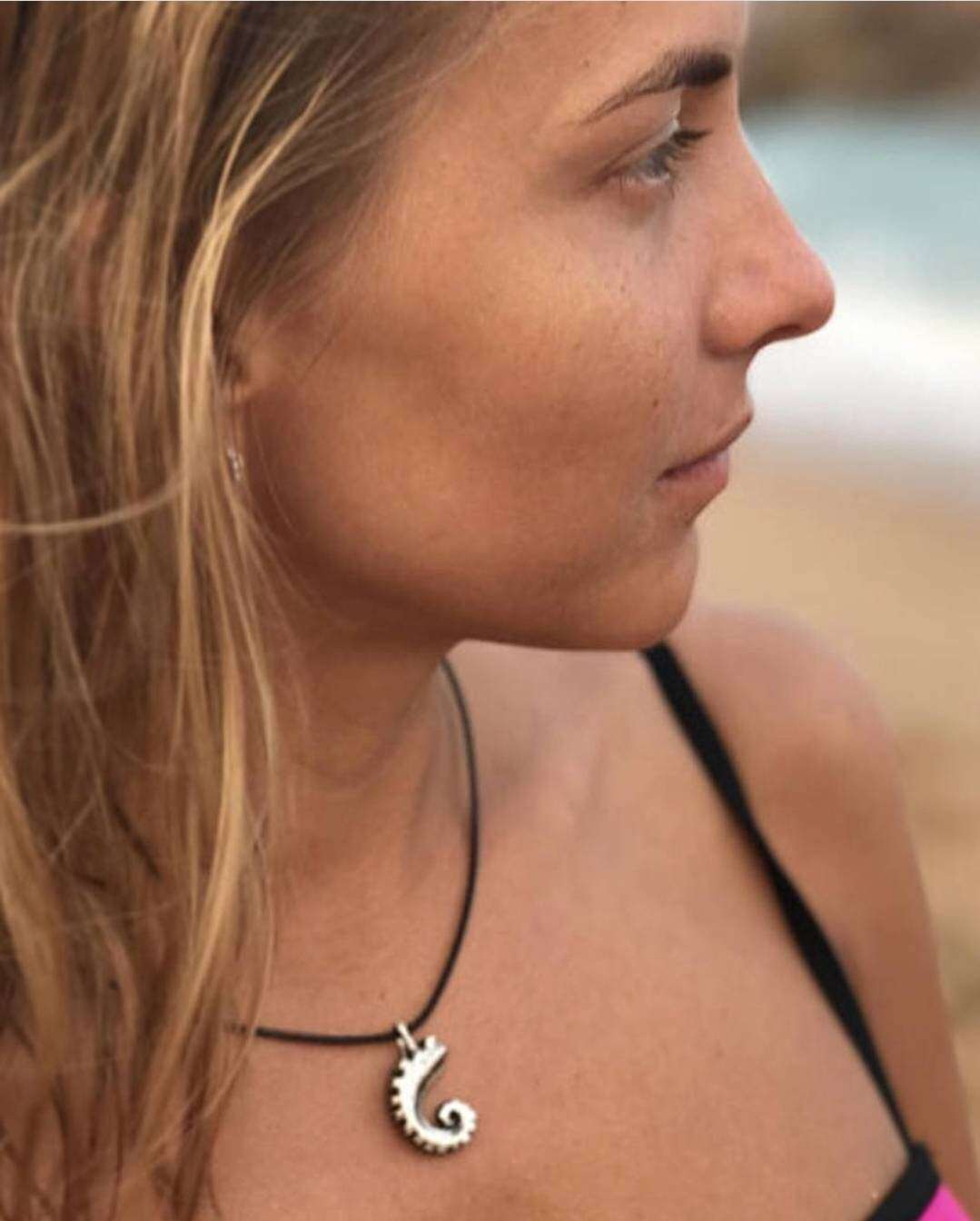 Woman wearing the tentacle necklace at the beach, facing sideways.