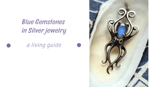 Blue Gemstones - Silver Octopus necklace with a blue labradorite, shown inside a white seashell with indigo textile background