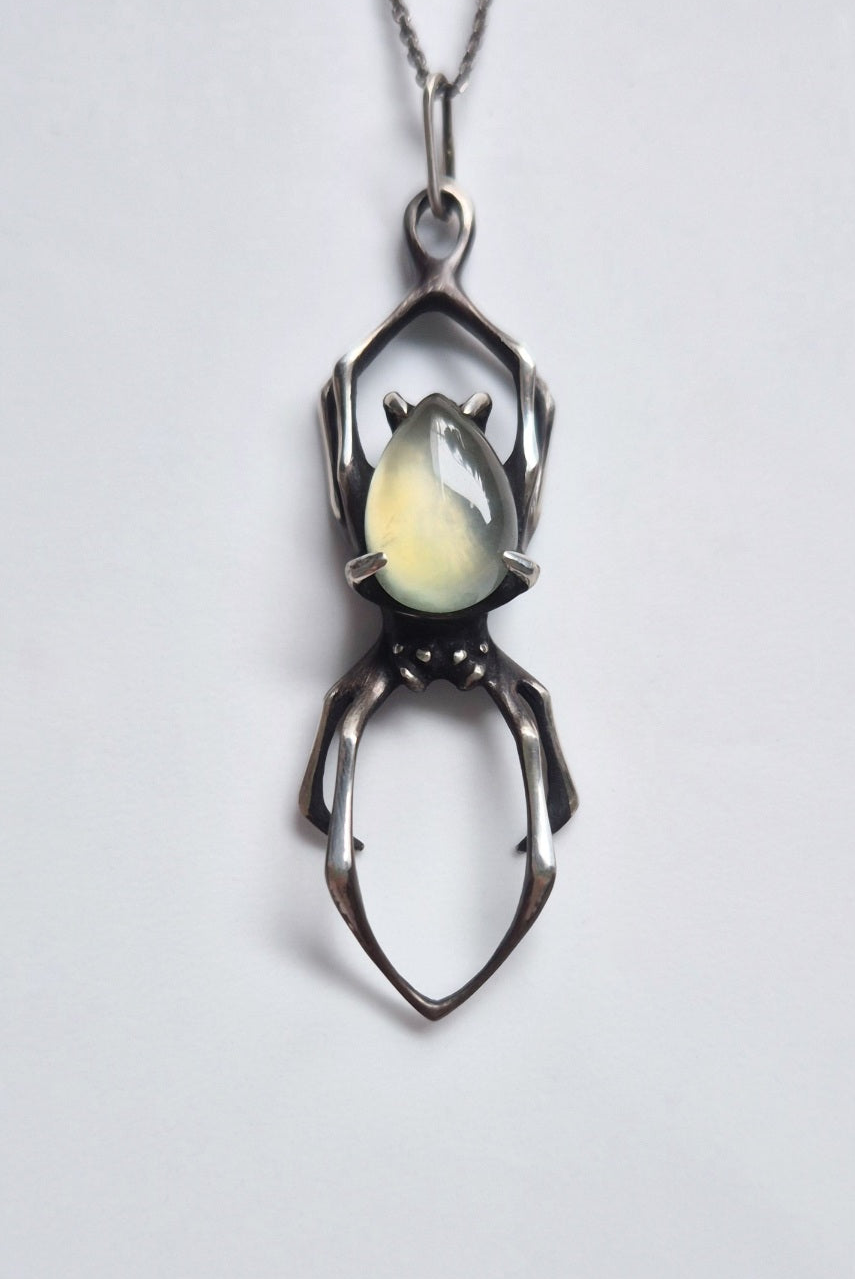 Front view of the oxidized sterling silver spider necklace with translucent green prehnite