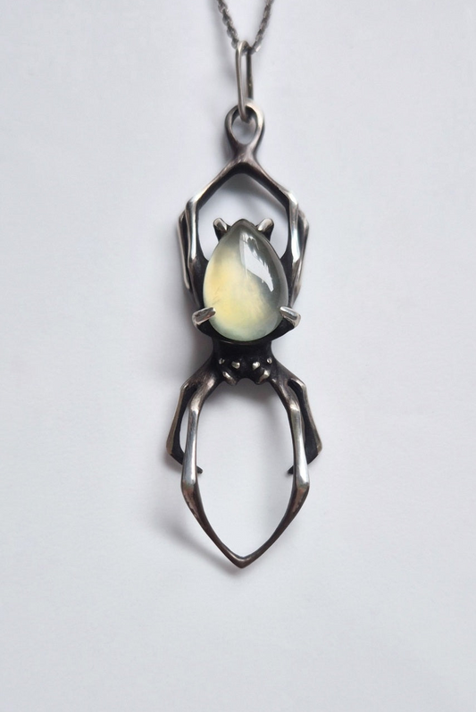 Front view of the oxidized sterling silver spider necklace with translucent green prehnite