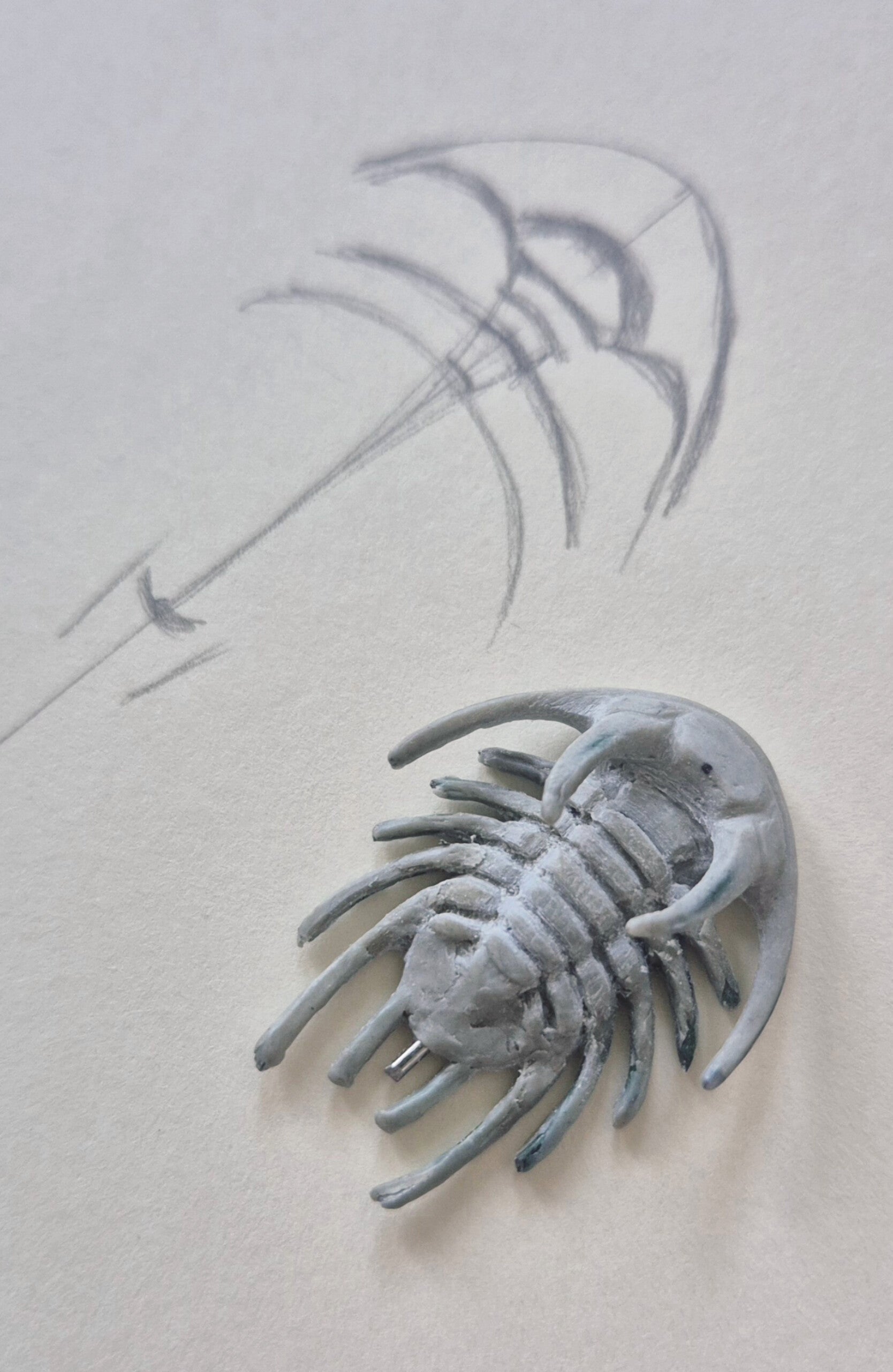 Trilobite necklace master model showing the wire armature and the sweeping curve of the head and horns.