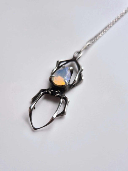Spider pendant in silver with natural Opal gem on white background
