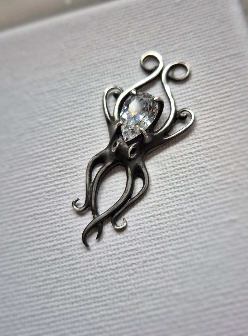Close-up of the silver octopus necklace with clear zircon, photographed against a neutral background.