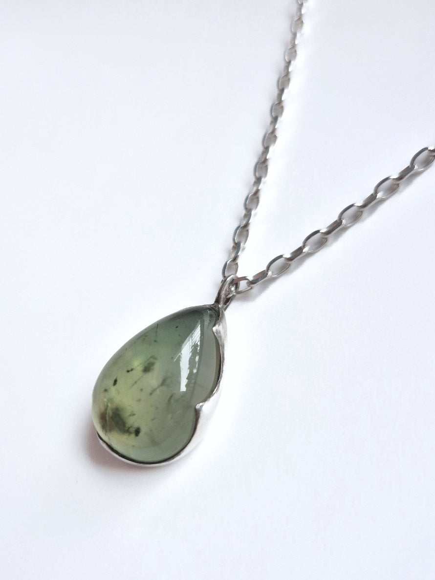 Sterling silver prehnite necklace displayed on white fabric