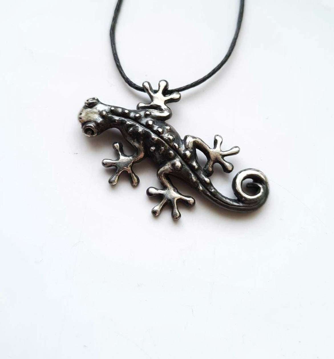 Close-up of oxidized silver Gecko necklace on white background, showing detailed limbs and curled tail.