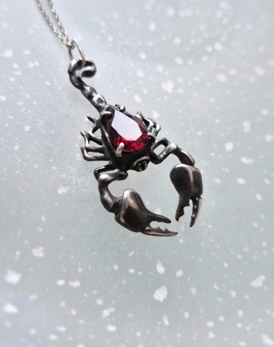 Scorpion necklace in Sterling Silver with Garnet gem, shot of neutral background