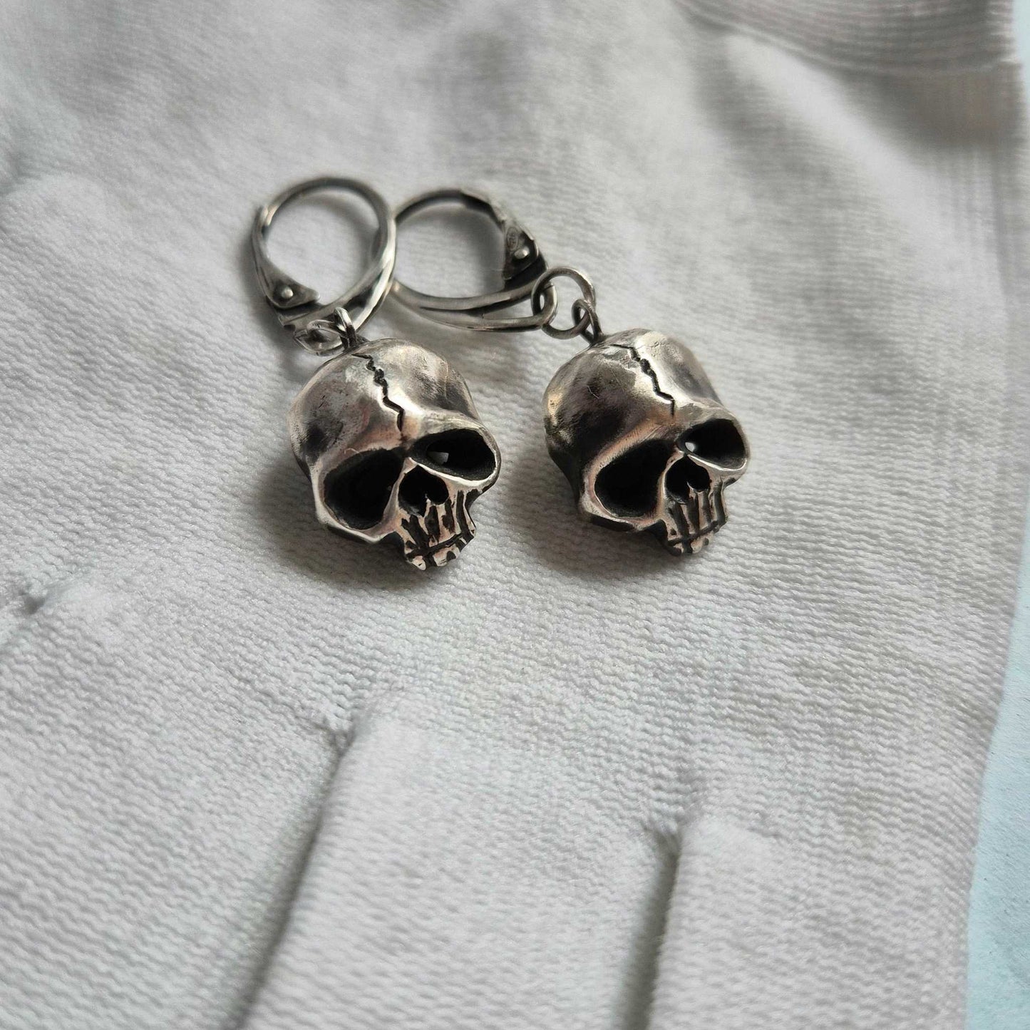 Skull earrings showcasing oxidized silver finish