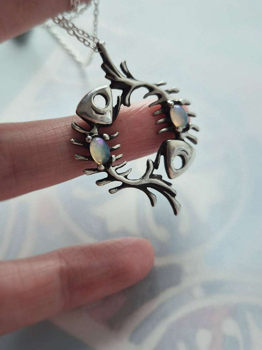 Detailed view of Fish necklace, two fish skeletons forming a loop, each with an opal gemstone
