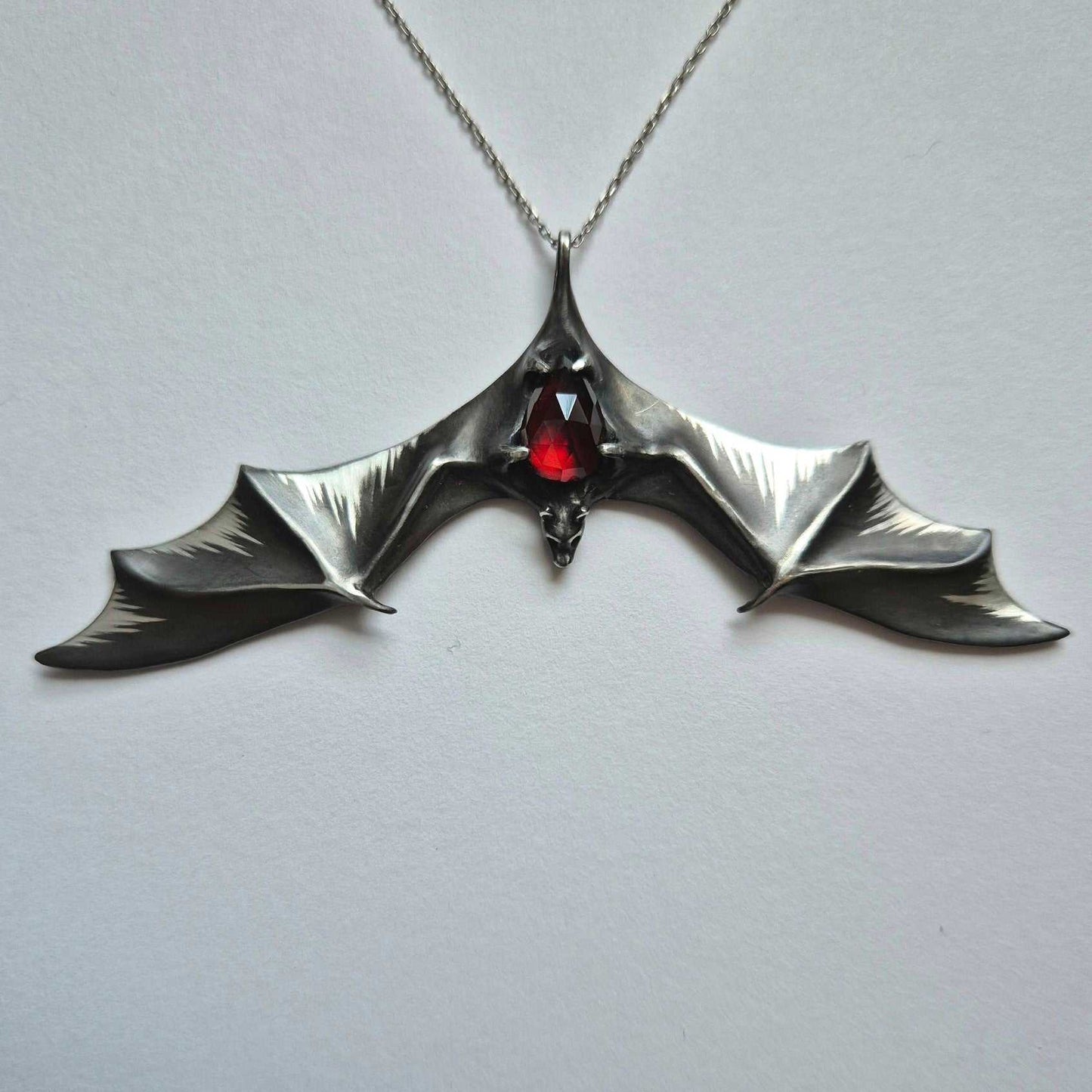 Dragonblood Bat pendant with a garnet gem, handmade Witchy silver talisman