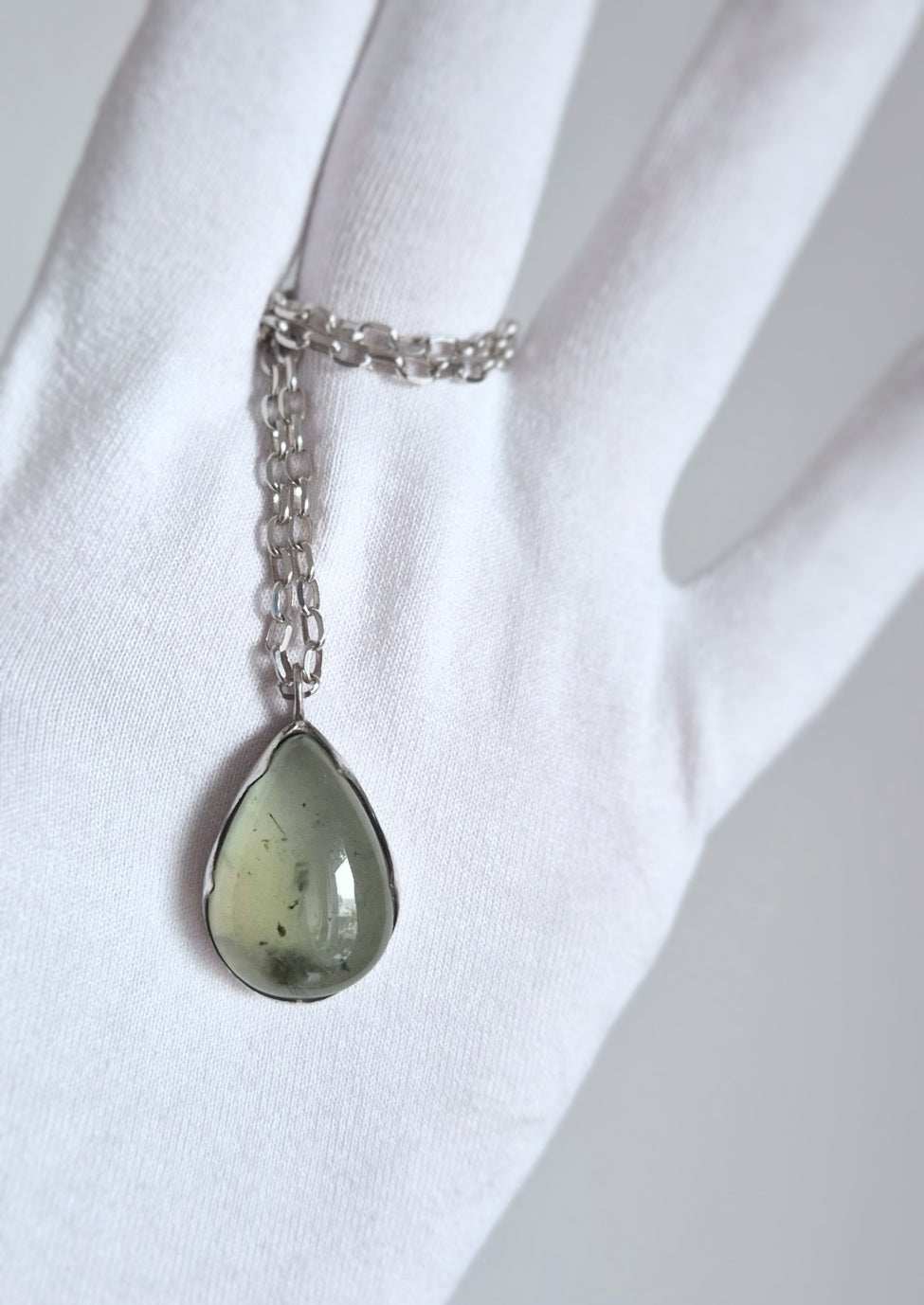 Minimalist prehnite pendant on silver chain displayed vertically