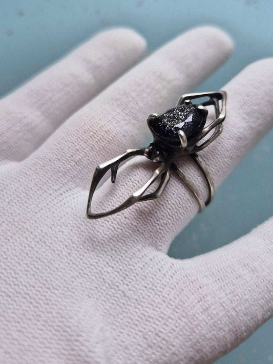 Statement spider ring with iolite sunstone on a white-gloved hand