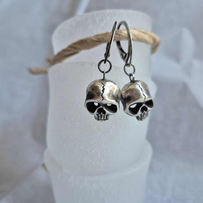 Pair of skull earrings hanging on display