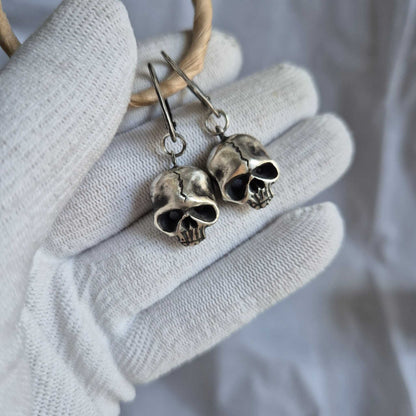 Close-up of skull earrings on white fabric